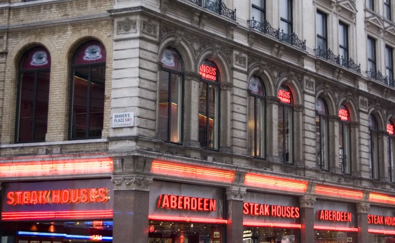 a building in an urban setting with many different types of neon signs