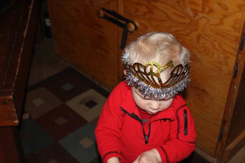 a baby with a paper crown on her head