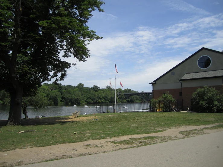 a building with an american flag on a grassy field next to water