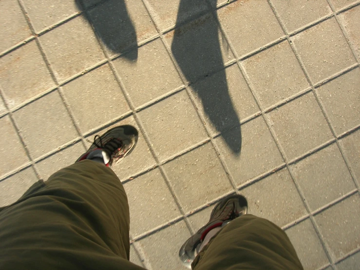 a man standing on the sidewalk with his feet in the air
