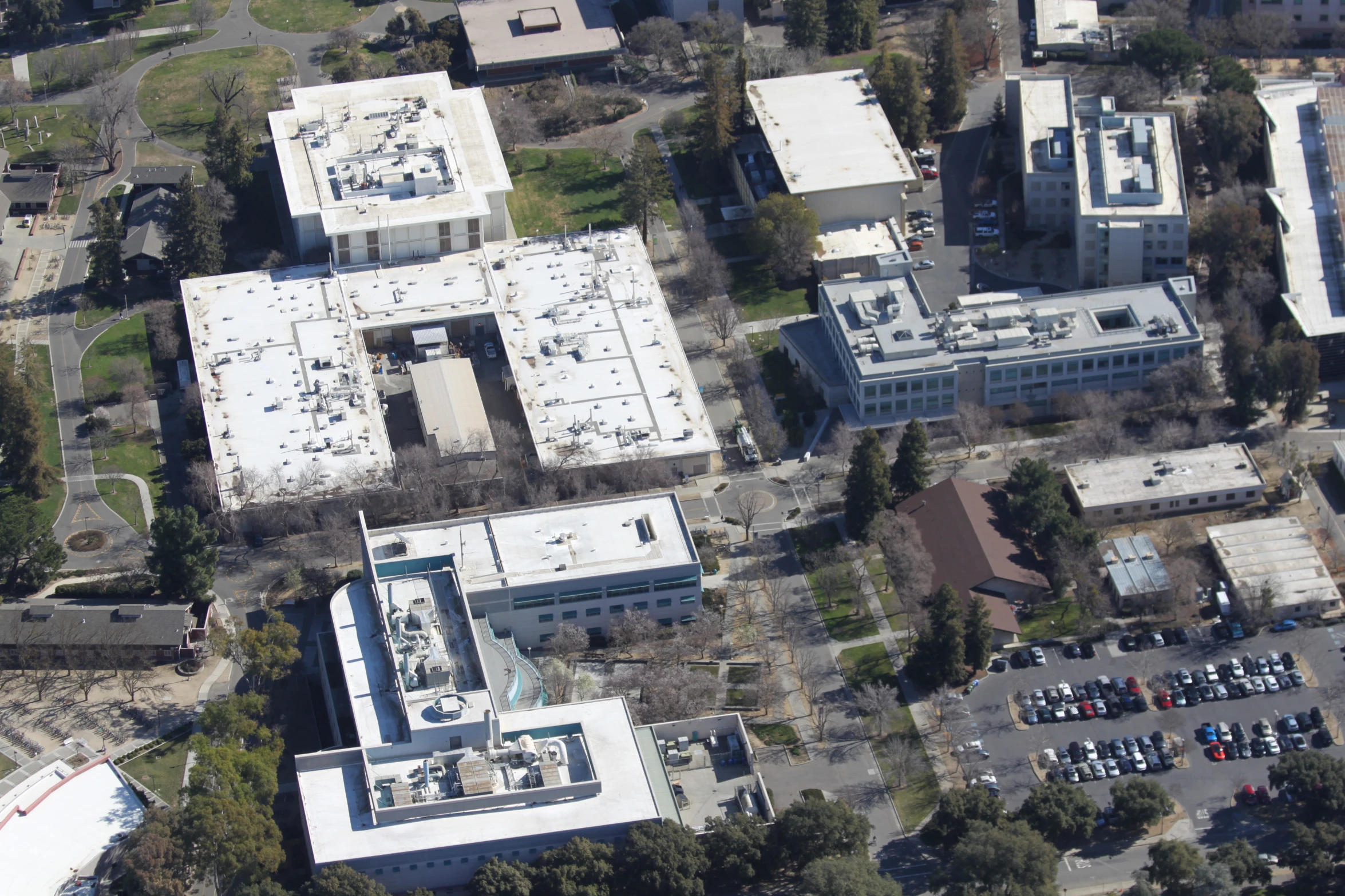 an aerial view of a white building with lots of parking spaces