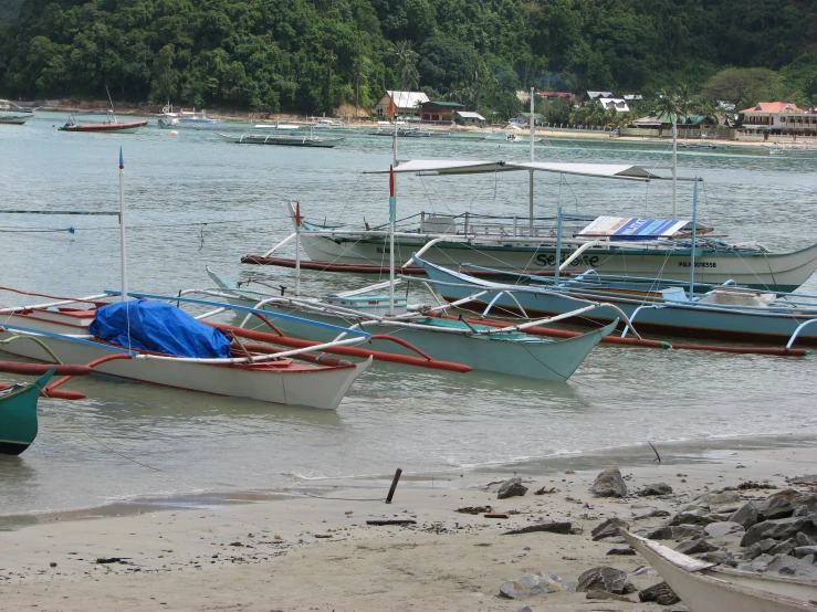 boats docked in shallow ocean water near shore