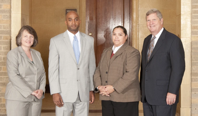 three people standing in front of wooden doors