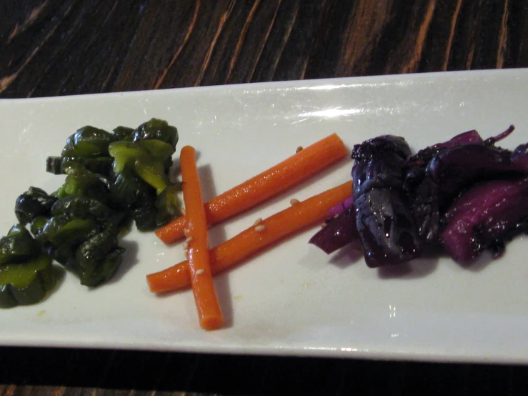 a white plate topped with carrots and broccoli