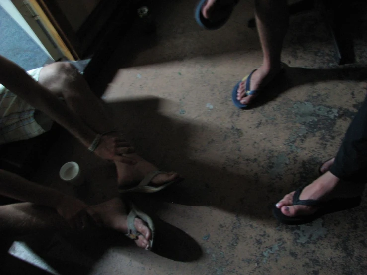 people standing around a bathroom floor with one of them showing the reflection