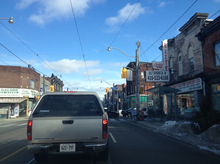 truck on street with power lines above cars