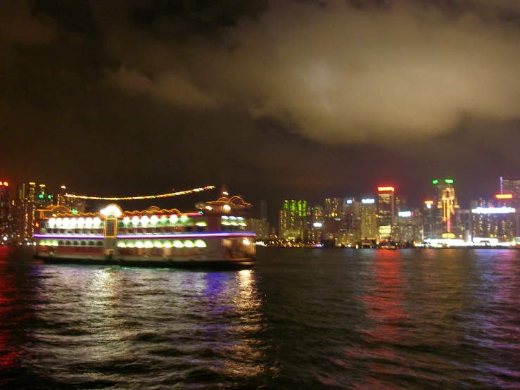 a large ferry sailing in front of a large city