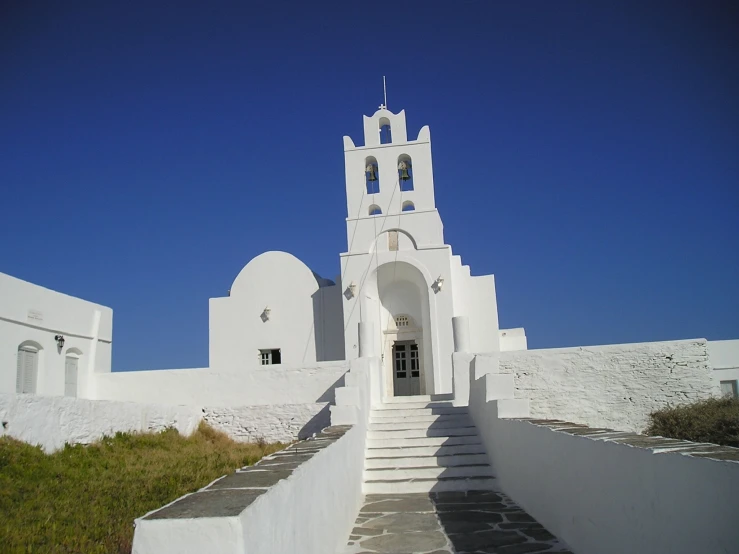 an old church on the corner with white walls and windows