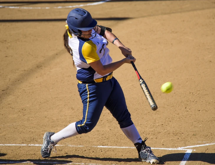 a woman batting on a softball field with a bat