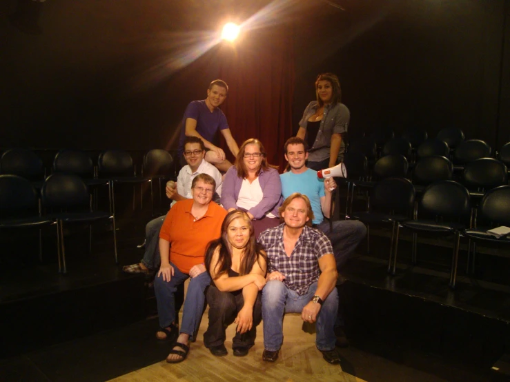 a group of people are sitting together in a dark room