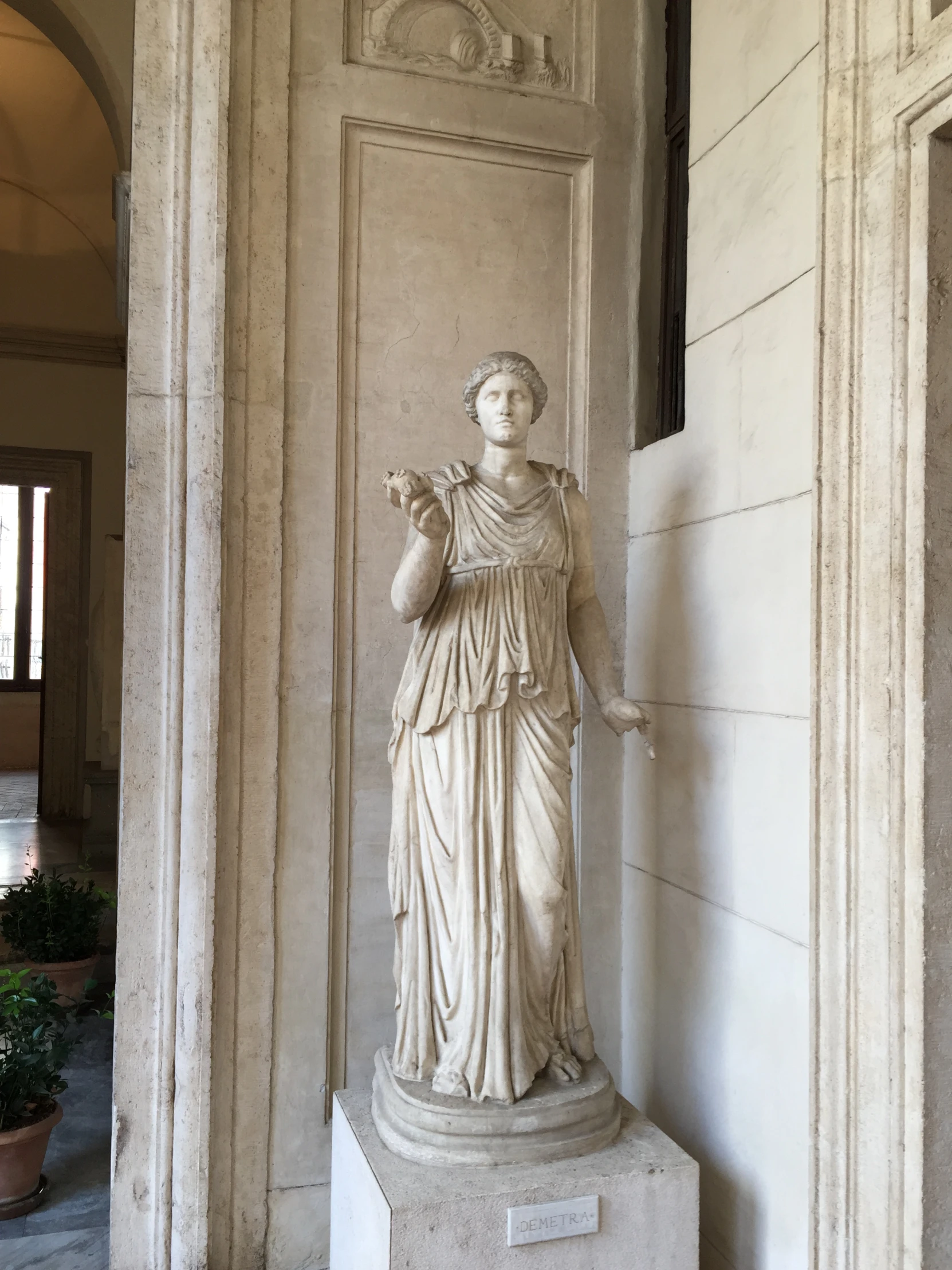 a white marble statue on display in an elegant courtyard