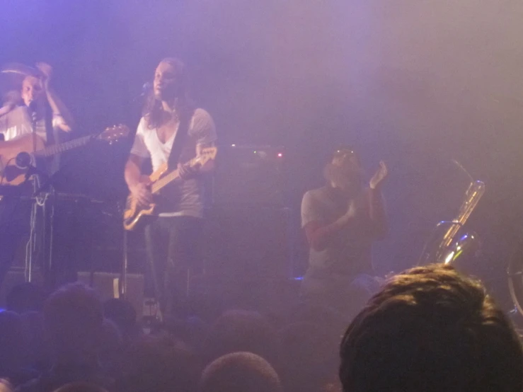 a group of people on stage playing musical instruments