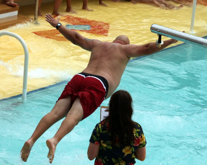 a person is doing a flip off a swimming board in the water