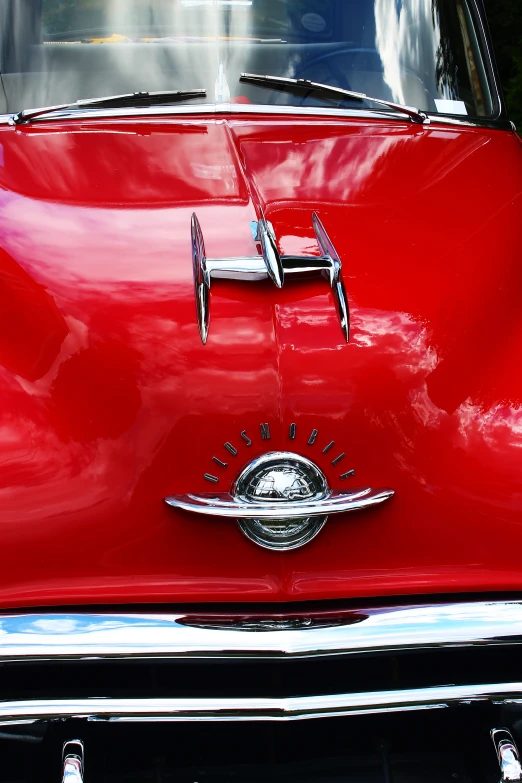 the side of a red car with chrome lettering