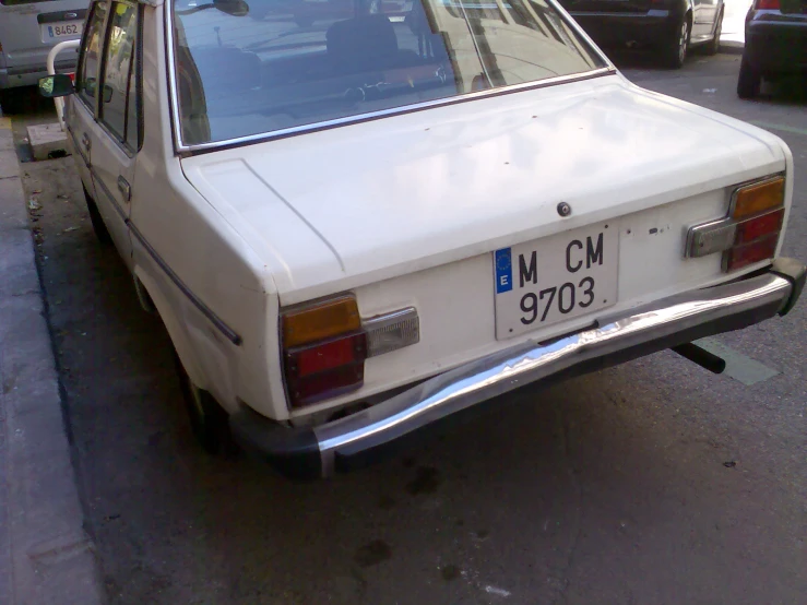 an old white station wagon parked on a street