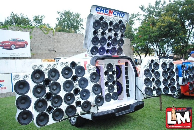 a large truck has speakers on it with other cars and trucks behind