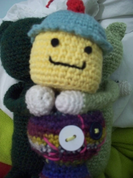 a stuffed toy with a crocheted hat holding a bag