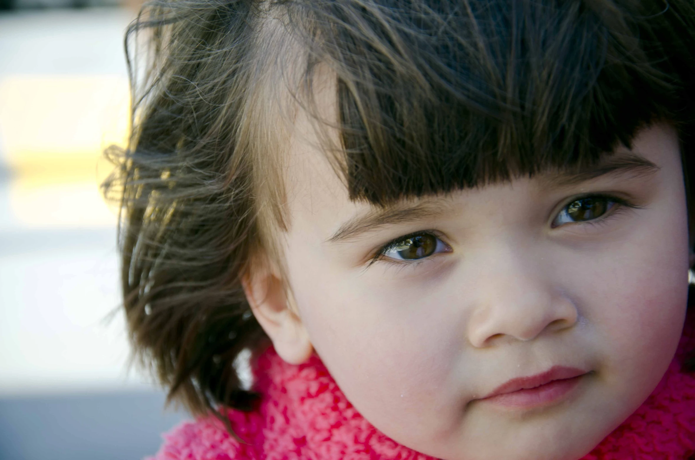 a little girl with a pink scarf on