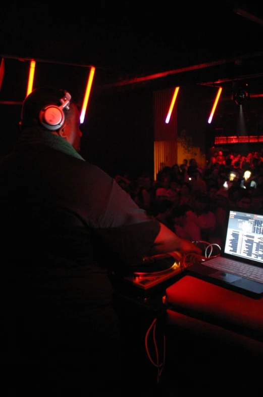 a man using his computer in front of a crowd