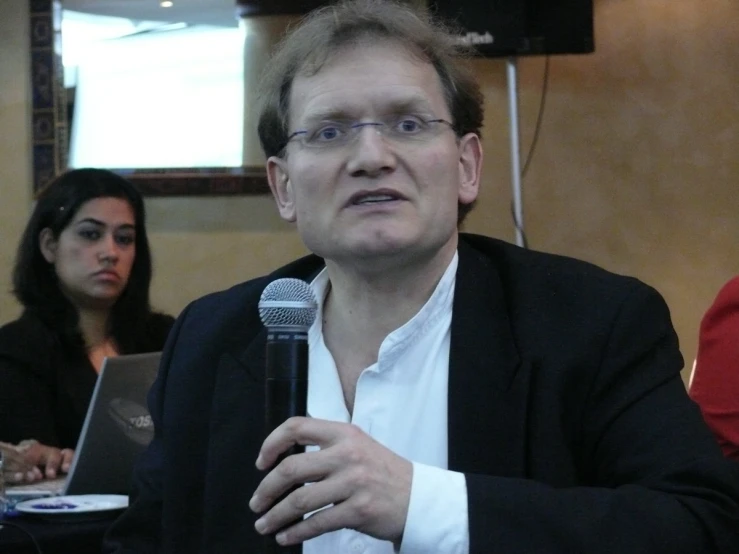 a man sitting next to a woman in a white shirt