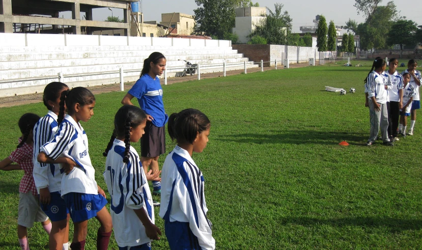 several children stand around and talk with some coach