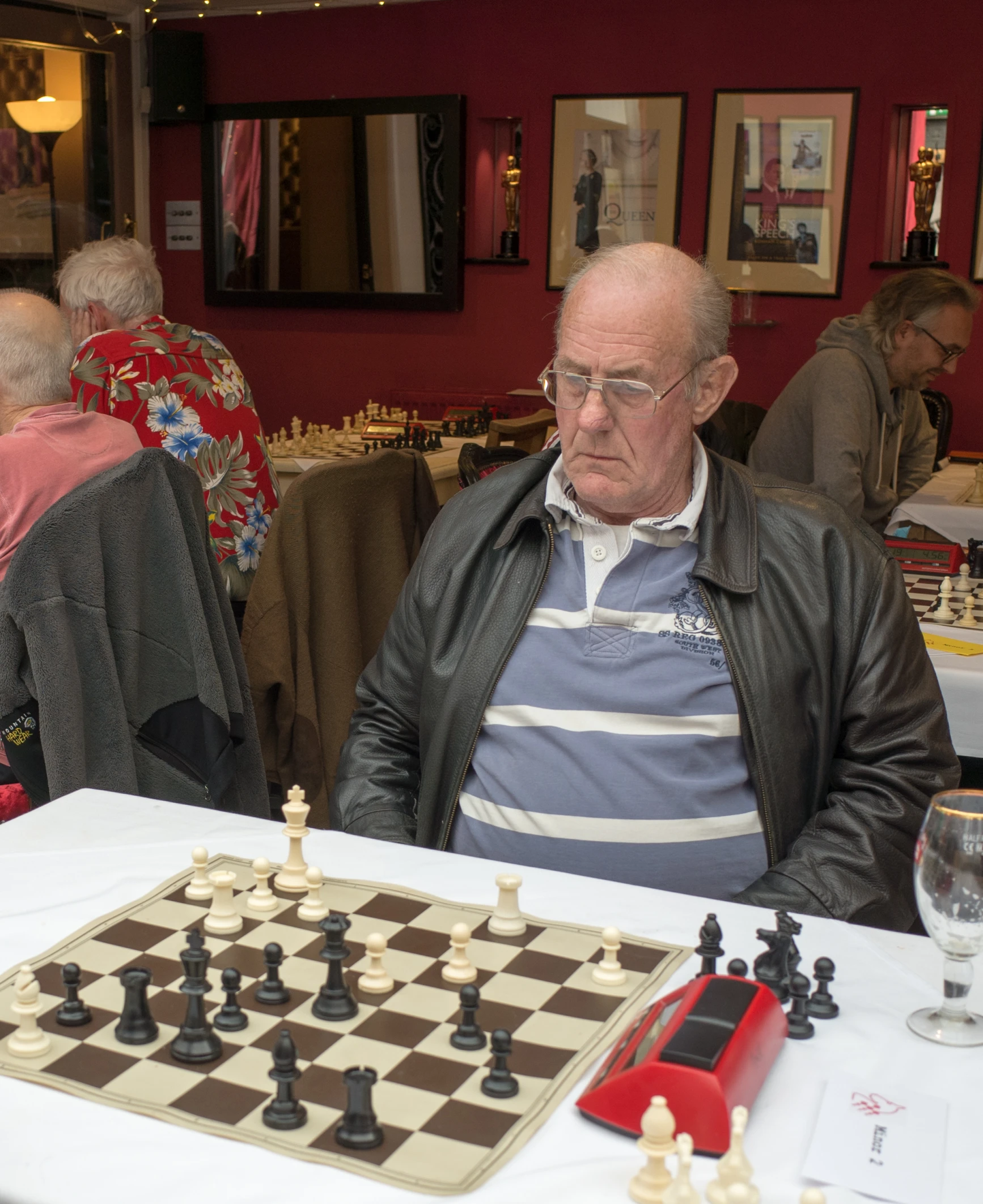 a man sitting at a table next to a chess board