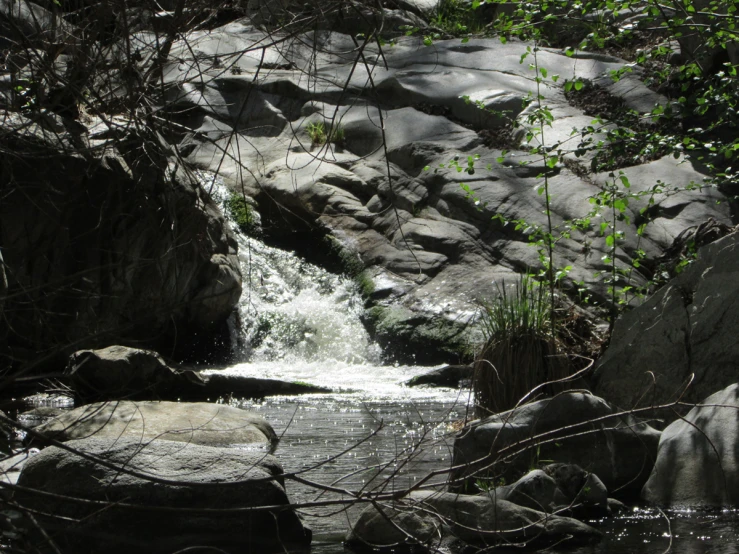 the water is rushing down the rocks and into the pool