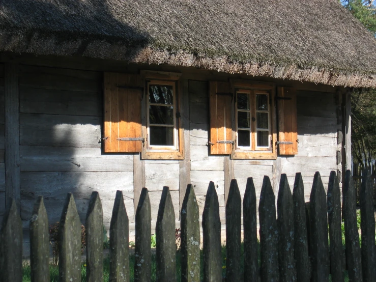 wooden picket fence in front of small house