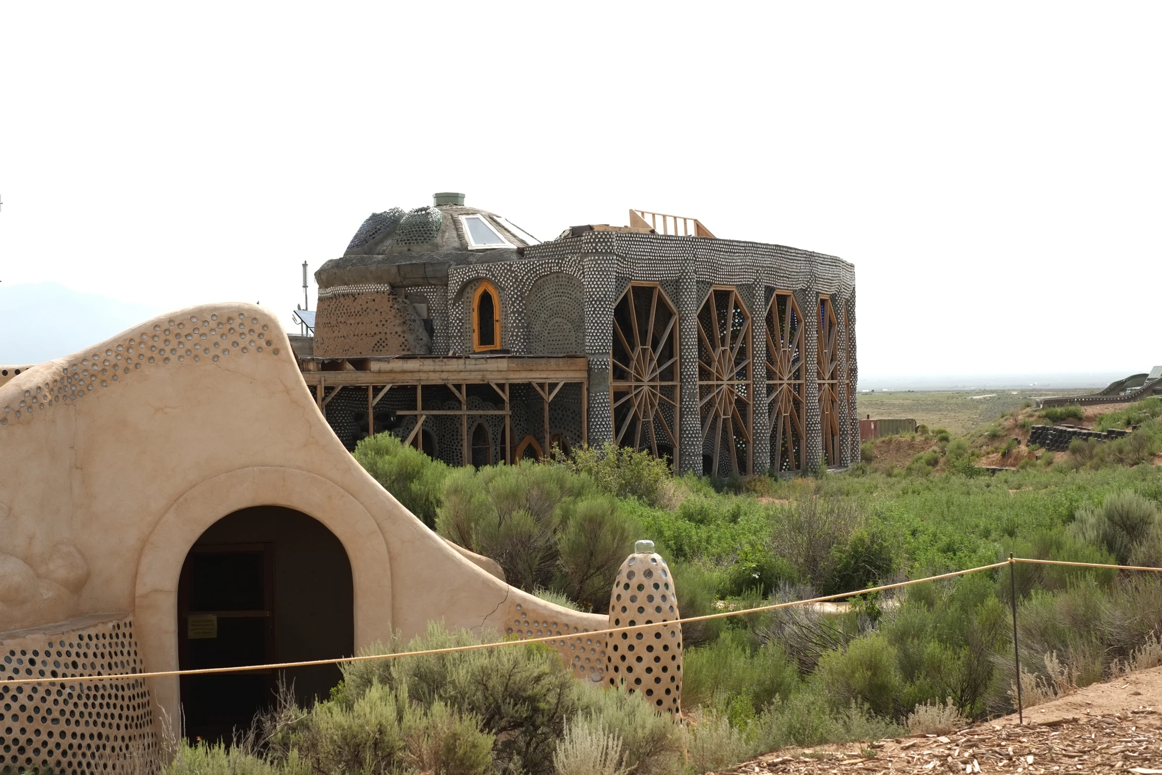 an unusual building is surrounded by grass