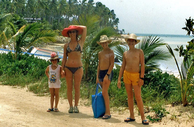 three people on the beach posing with hats and bikinis