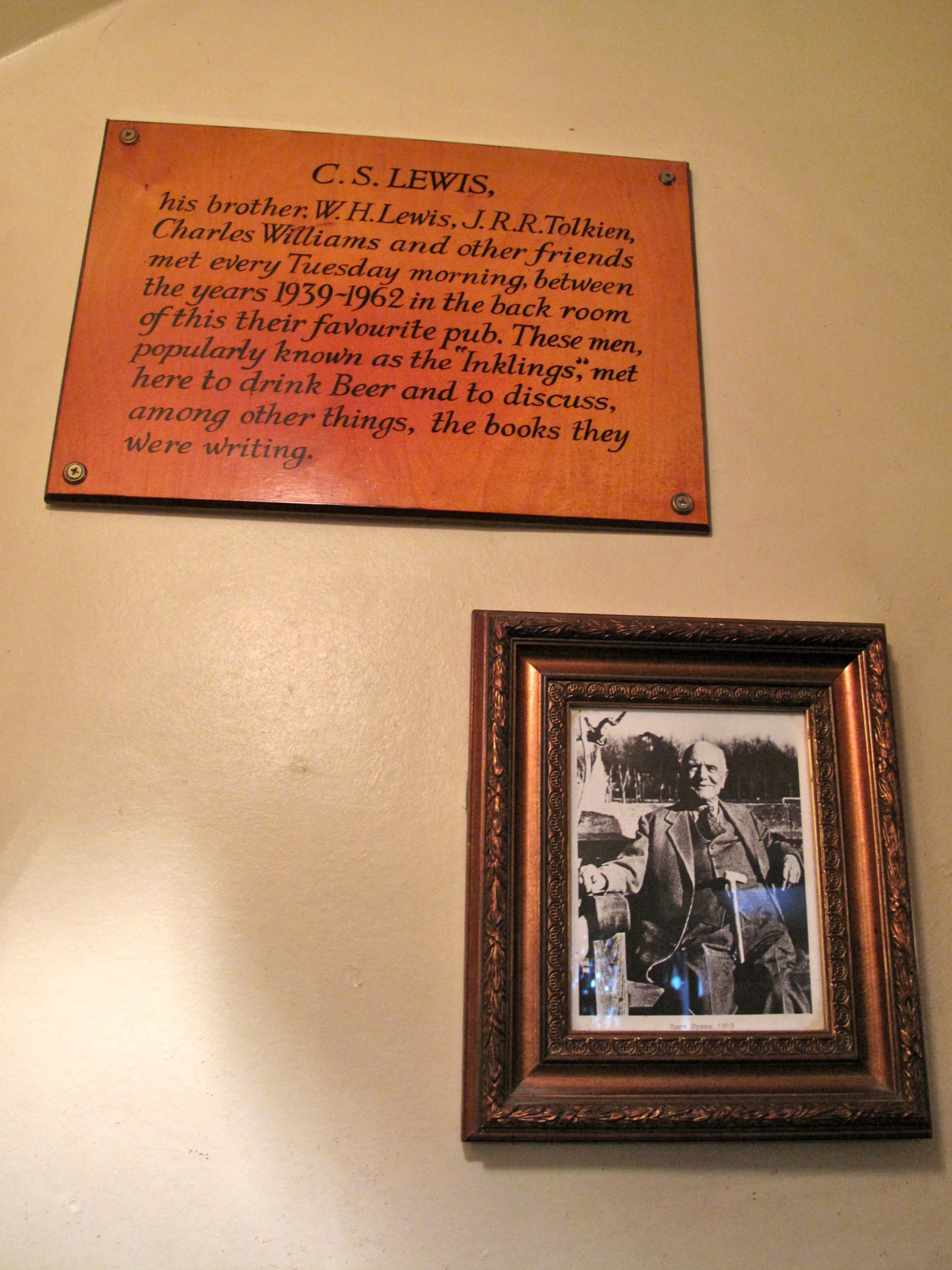 a plaque and framed pograph of lewis on a wall