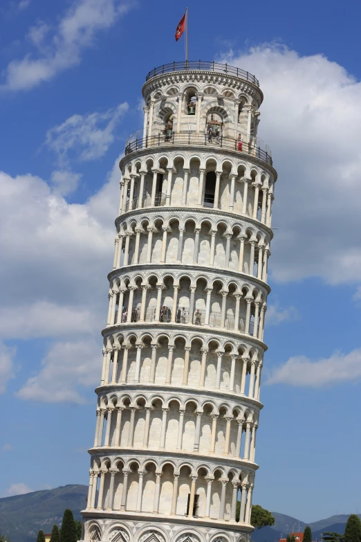 the leaning clock tower is in the middle of a park