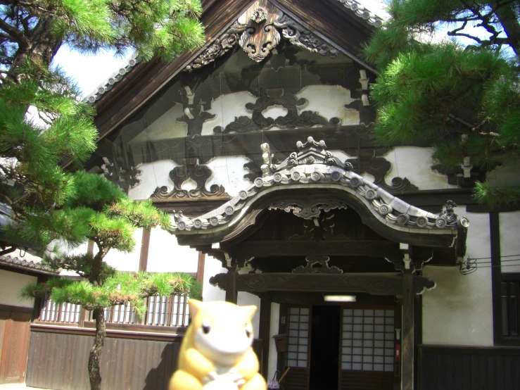 a small sculpture of a cat outside of a large building