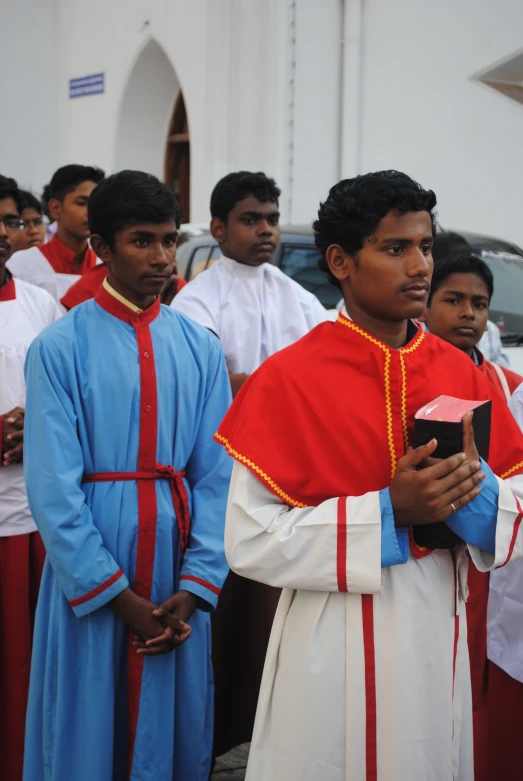 priest standing near people with other men in front of him