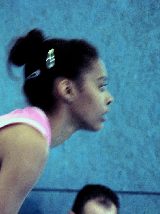 a girl is standing in front of a wall