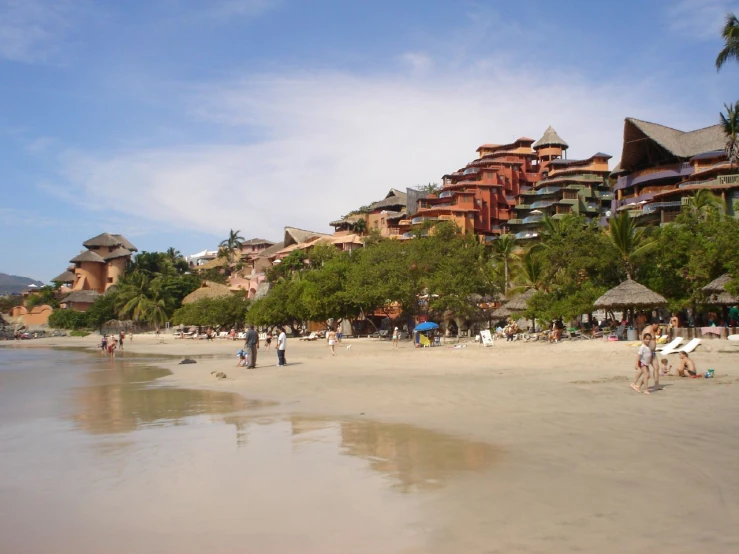 a beach with people walking around and a tall el in the background