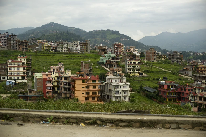 a small town on a hill with mountains in the background