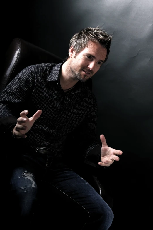 a man sitting on a chair posing for the camera