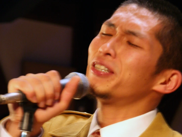 a man singing into a microphone in front of him