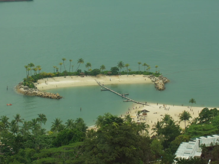 a white beach sits along a tropical bay
