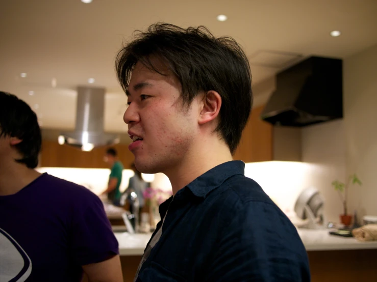 two men standing in the kitchen next to each other