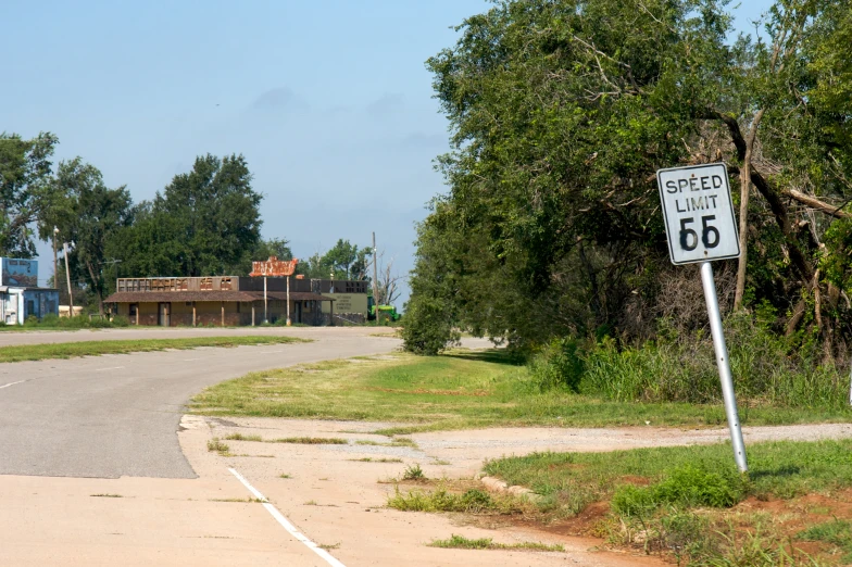 a street sign stands at the end of a deserted road