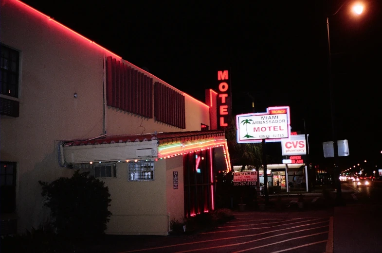 a motel with neon signs in the dark