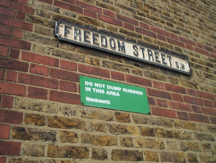 the street sign on a brick building indicates that the area in which the person lived was