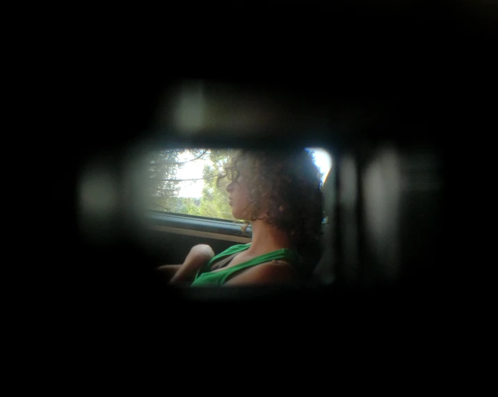 a woman looking out the window of an automobile