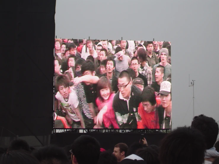 a group of people that are standing on a big screen