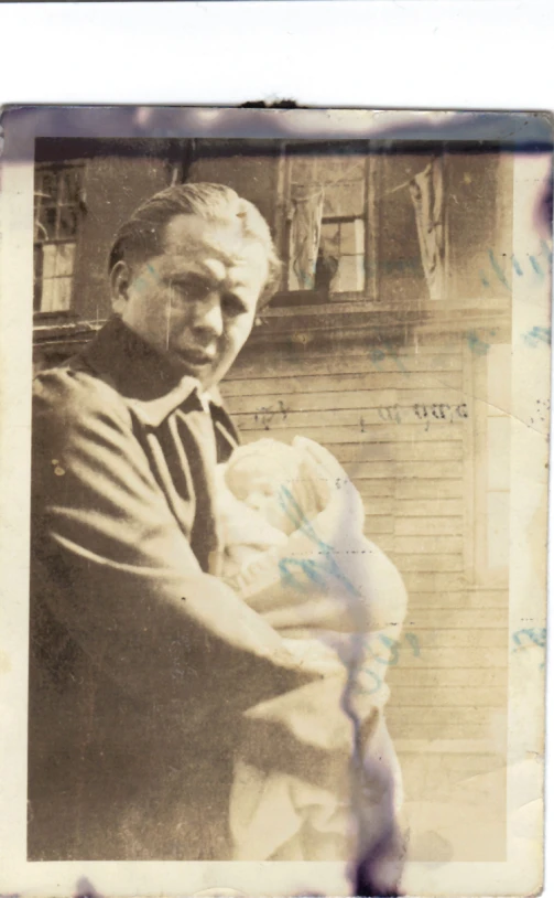 this old pograph of a man holding a baby in his arms