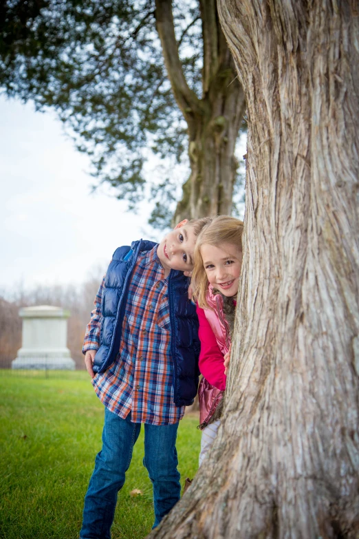 the two s are peeking out from behind the tree