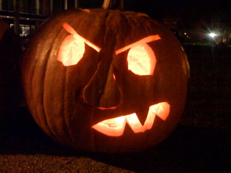 a halloween pumpkin with glowing pumpkin eyes is lit