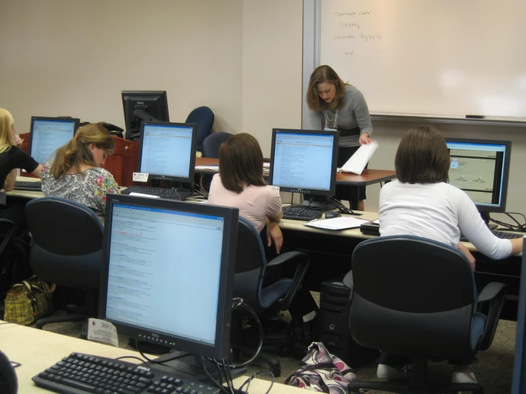 several women work on computers in an office setting